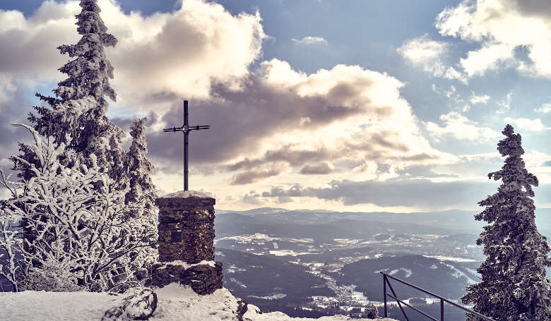 Von Schneegestöber bedecktes Gipfelkreuz des Großen Falkenstein.
